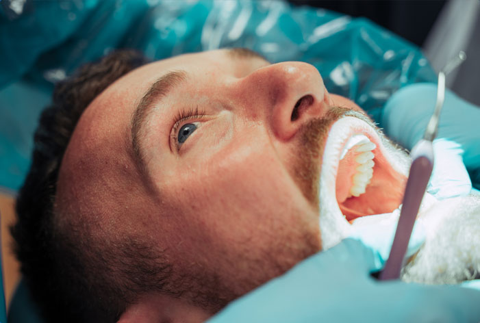 Stock image of male patient being tested with dental equipment