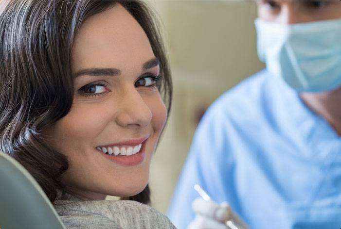 Stock image of a smiling patient in dental chair