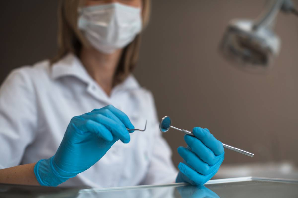 Dentist close-up with dental instruments.